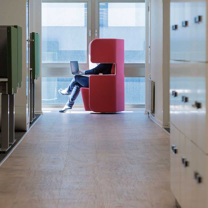 Woman working on Martela's PodSeat at Enfo's office in Stockholm, Sweden