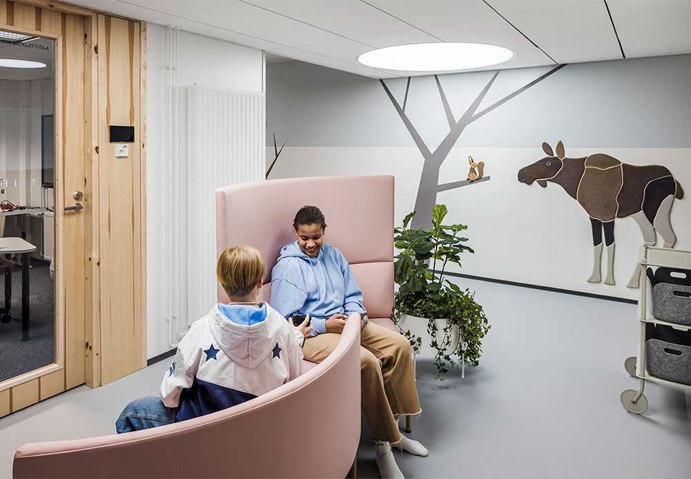 Pupils sitting in armchairs in the school corridor