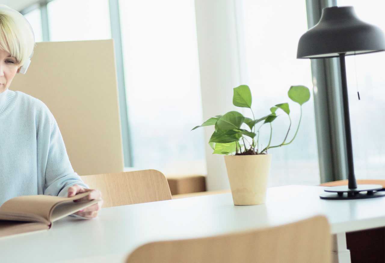 Woman reading by Martela table and Sola chairs