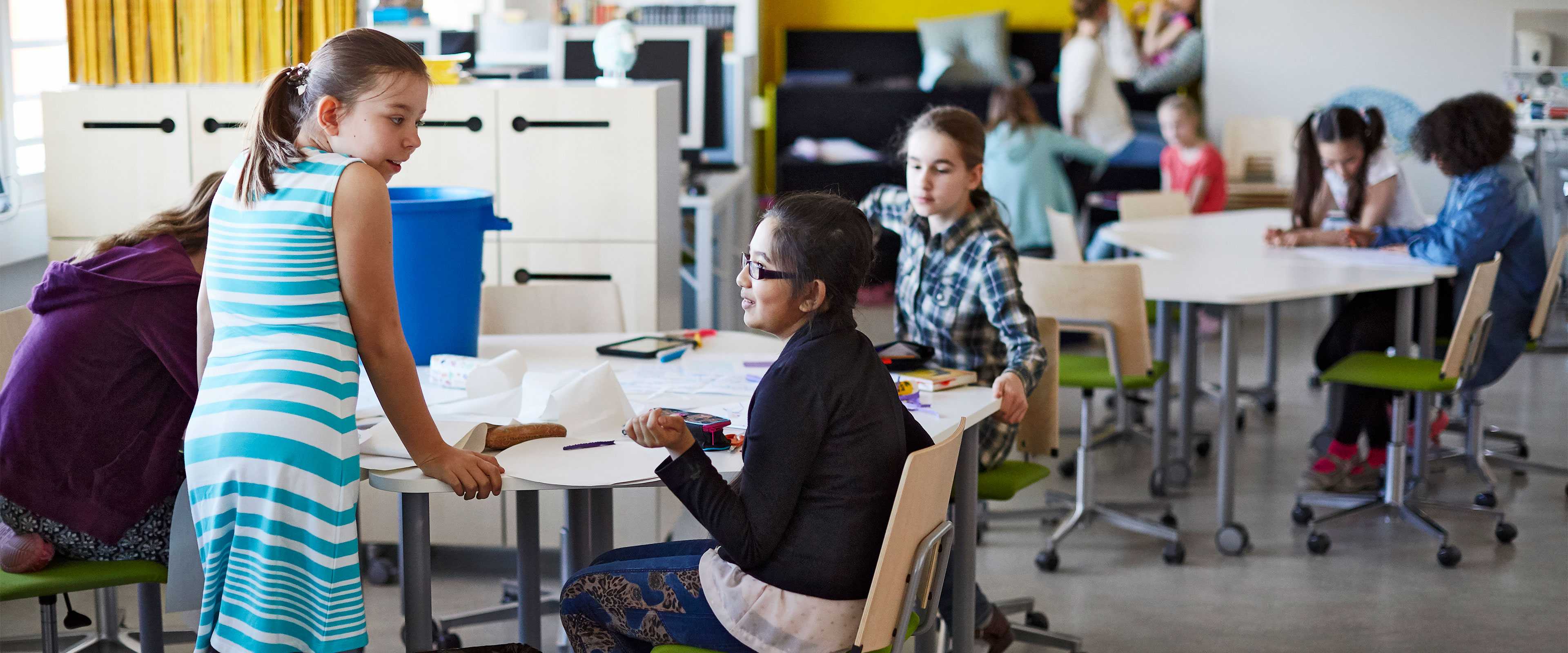 Pupils studying at Martela's Salmiakki tables and Grip chairs in English School in Helsinki