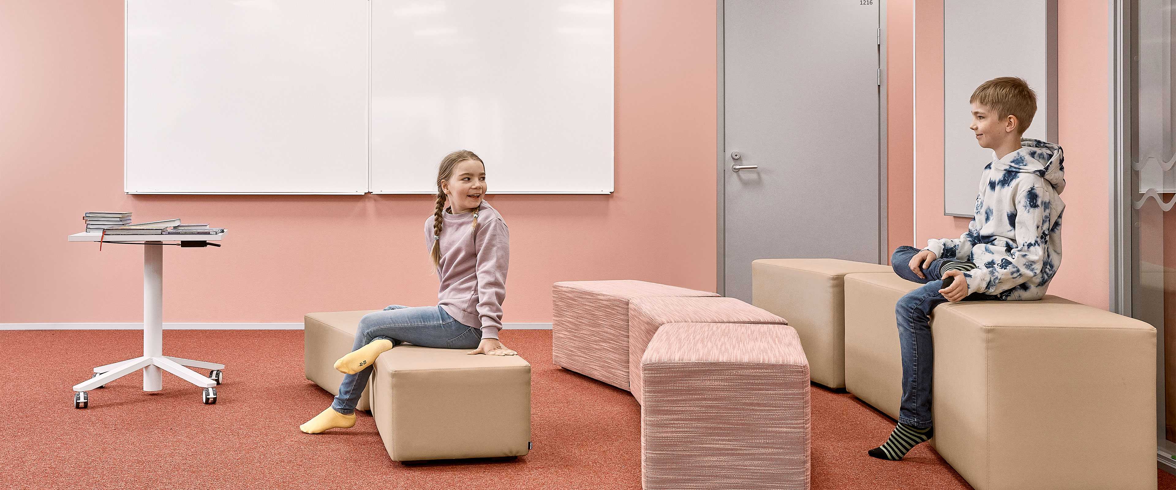 Två elever sitter på Bit sittpuffar