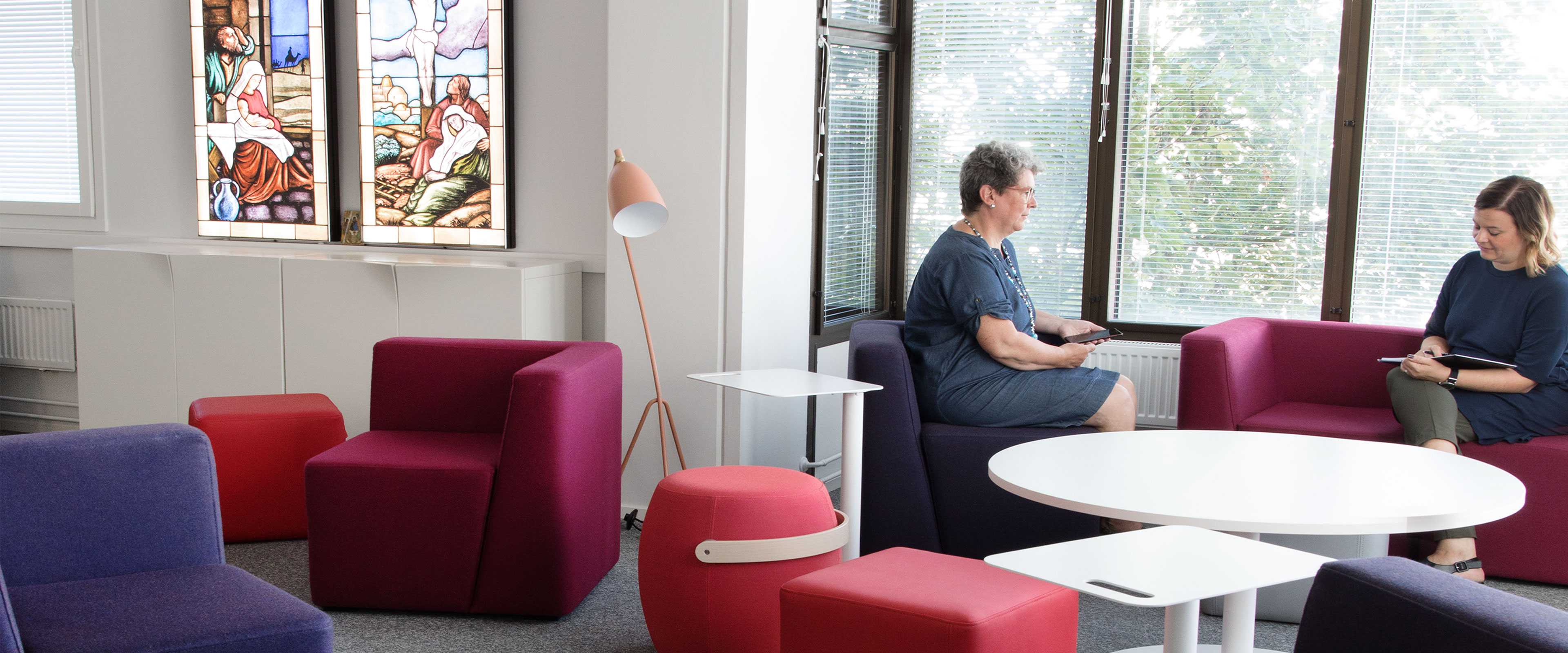 Women sitting at Martela's Bit stools and sofa at FELM's office