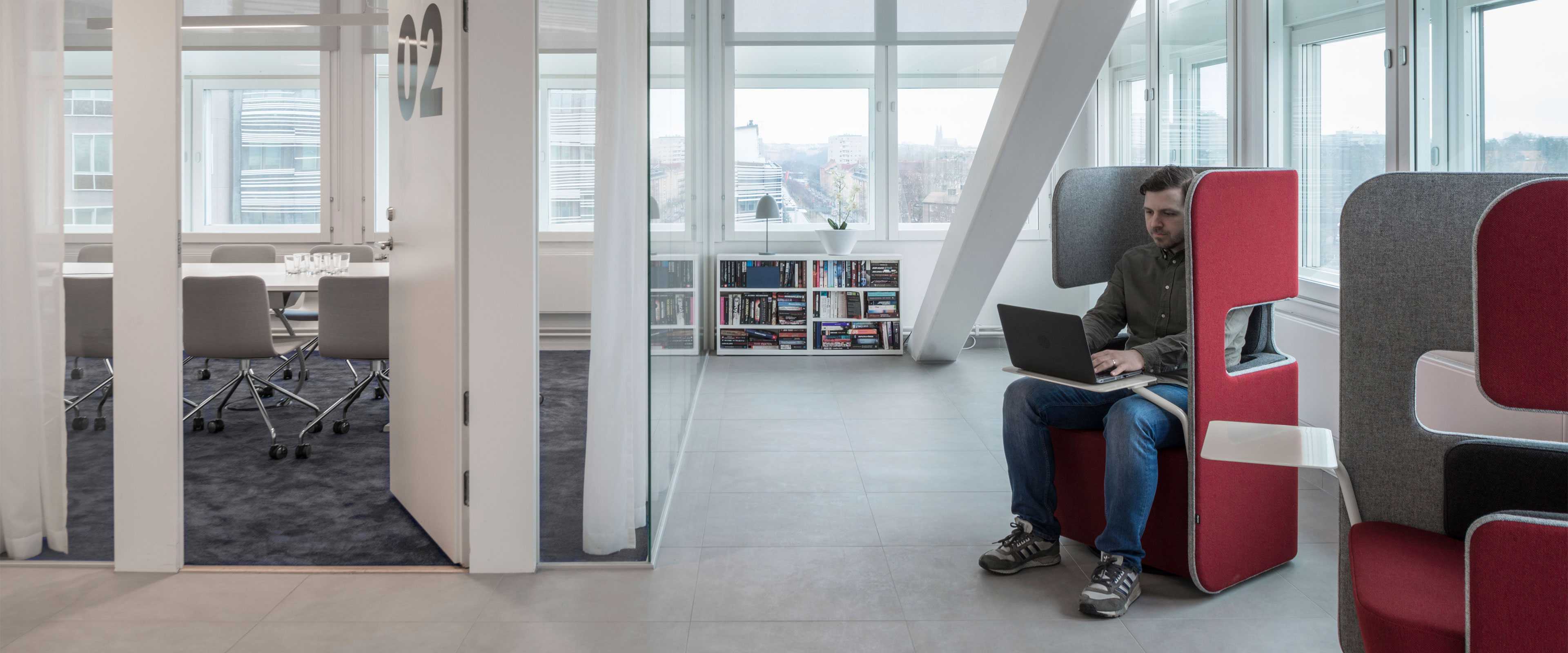 Man working on a laptop at Martela's PodSeat in Vitec's office