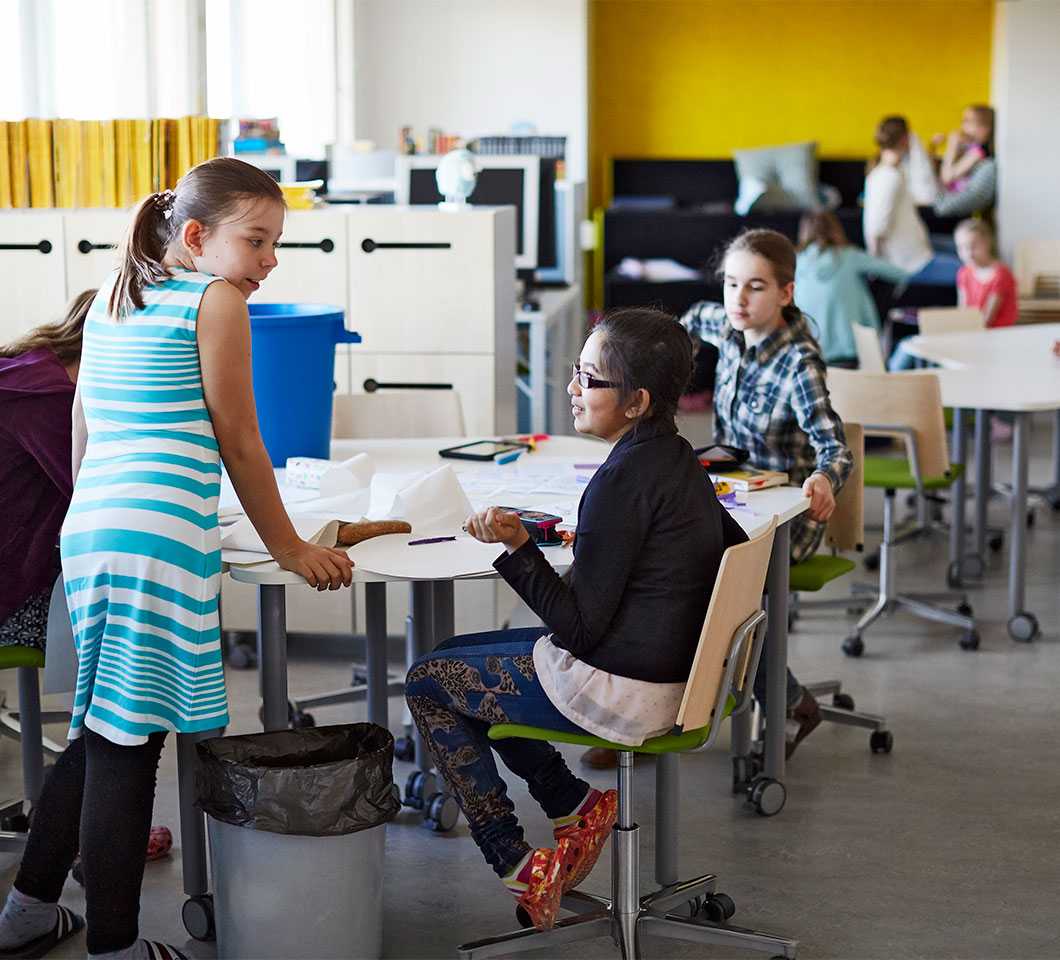 Pupils studying at Martela's Salmiakki tables and Grip chairs in English School in Helsinki