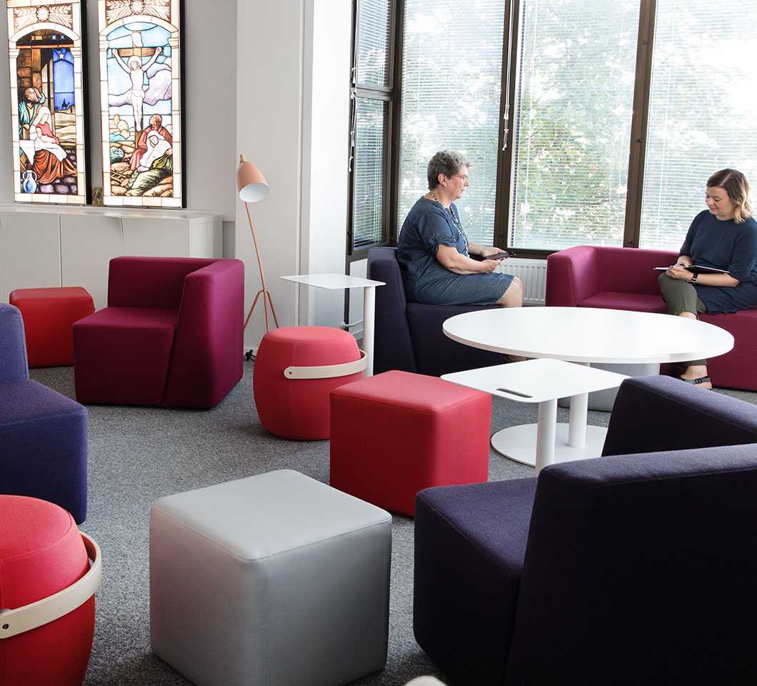 Women sitting at Martela's Bit stools and sofa at FELM's office