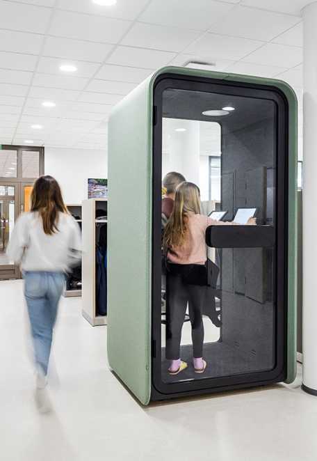 Two students studying in a PodBooth phone booth