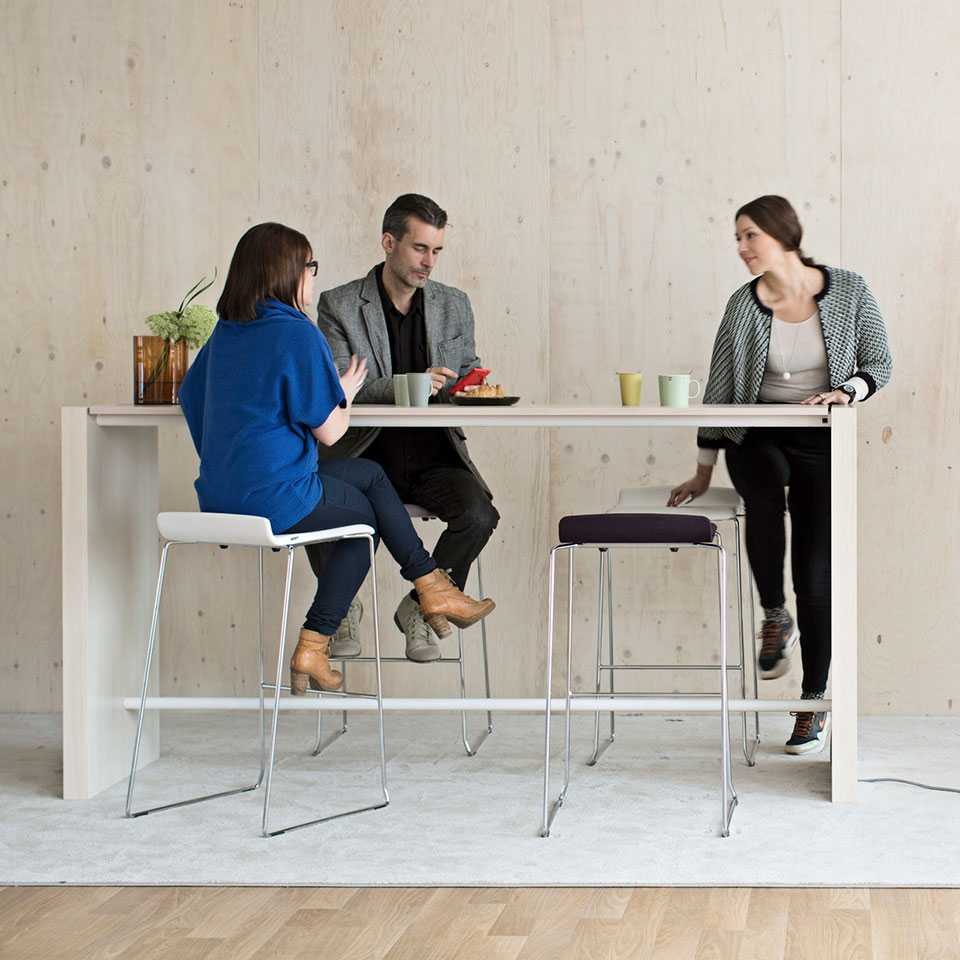 People gathering around a standing height desk