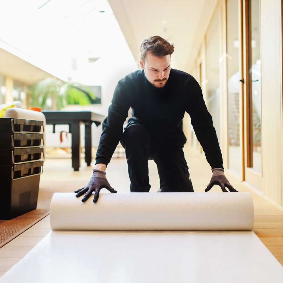 A moving staff member decorating with rugs.