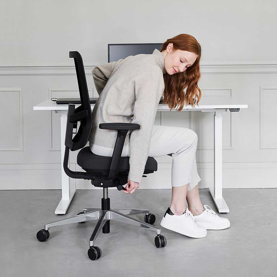 A woman adjusts an office chair